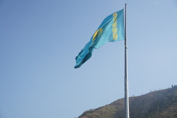 Fototapeta na wymiar Almaty, Kazakhstan - 09.16.2022 : The national flag of the Republic of Kazakhstan on a large flagpole in the city center.