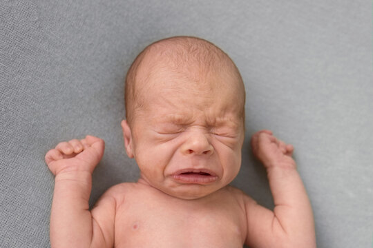 portrait of crying newborn baby. emotions of discontent. colic.