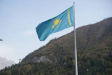 Almaty, Kazakhstan - 09.16.2022 :  The national flag of the Republic of Kazakhstan on a large flagpole in the city center.