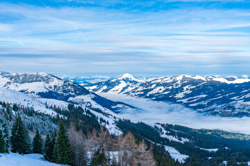 Fototapeta na wymiar Aerial view of wintry landscape in Austrian Alps above low clouds covering Kitzbuhel in Austria