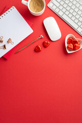 8-march concept. Top view vertical photo of notepads heart shaped saucer with candies mug of frothy coffee keyboard computer mouse golden pen and binder clips on isolated red background with copyspace
