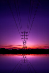 Silhouette High Voltage Electric Transportation.High voltage transmission pole against sunset...
