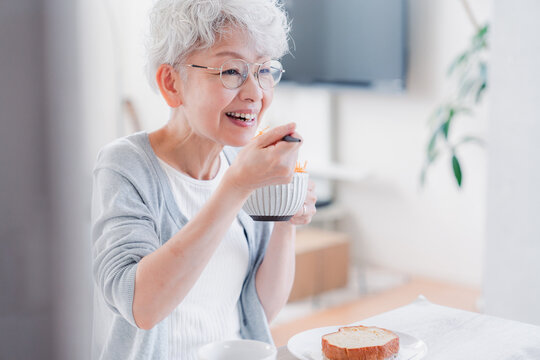 笑顔で朝食を食べるシニアの女性