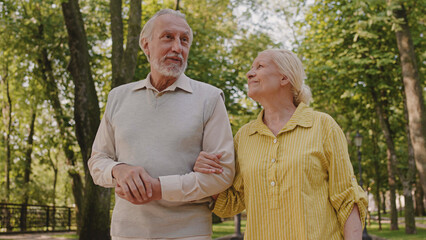 Happy retired couple walking in park together, family relationship, leisure