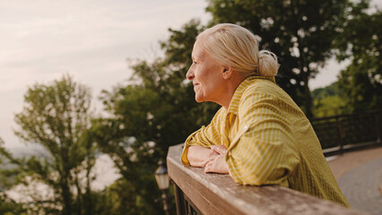 Happy senior woman enjoying city view in park, fresh, air, positive emotions