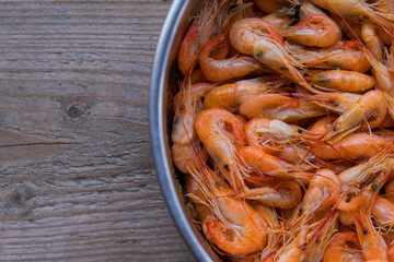 The top view prawns is a seafood. Bring it to boil until cooked to make an orange color look appetizing. In silver tray That was placed on brown wooden block. Copy space