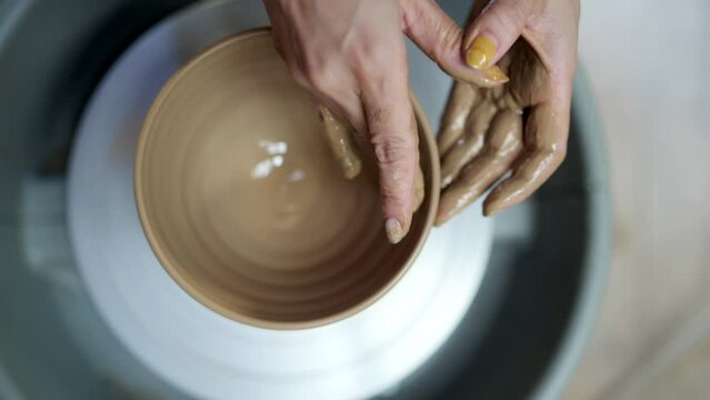 陶芸家の作業をする手のクローズアップ	真俯瞰
