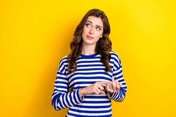 Photo portrait of pretty young girl look empty space calculate fingers wear trendy striped garment isolated on yellow color background