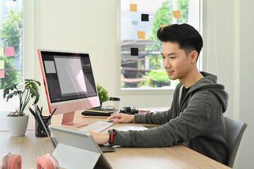 Asian man video editor working with footage and post production montage in creative office studio