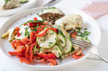 Zucchini salad with tomatoes and bell peppers marinated with olive oil, honey, vinegar and herbs