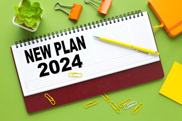 NEW PLAN 2024. text on a diary on a green background