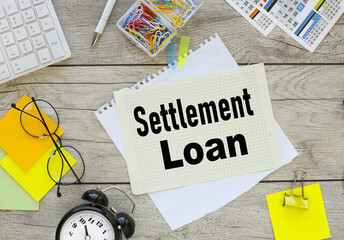 Settlement Loan . calendar pages and multi-colored paper clips near a notepad with text.