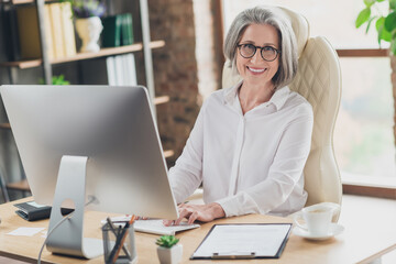 Photo of intelligent banker lady sitting leather chair keyboard write email loft interior office indoors