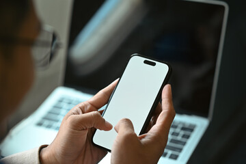 Cropped shot of businessman passenger checking work, news on smart phone, using wireless connection on board during flight