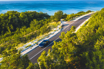 Driving on a coast road. Aerial view of a car driven on an amazing curved waving road at the Sea shore in Balchik sea resort in Bulgaria. © Dragoș Asaftei
