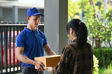 Delivery man giving postal package to customer at doorway. Delivery service, post and shipping concept
