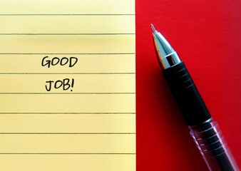 Pen and yellow note paper on red background with handwriting GOOD JOB!, praising someone for something they have done well -Boss or manager recognizing employees for good work