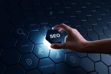 Hand of human putting hexagon piece to full fill the part of SEO Search Engine Optimization....
