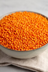 Red Lentils Legume in a Bowl on a gray background, side view. Close-up.