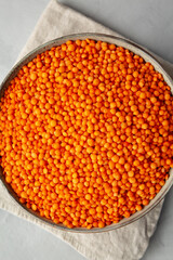 Red Lentils Legume in a Bowl on a gray surface, top view. Flat lay, overhead, from above. Close-up.
