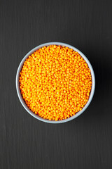 Red Lentils Legume in a Bowl on a black background, top view. Flat lay, overhead, from above.