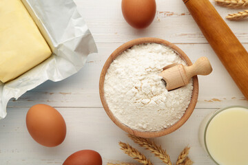 Ingredients for baking or cooking, egg flour, rolling pin butter, milk on a white wooden background Cookie pie or cake recipe.
