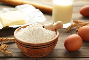 Ingredients for baking or cooking, egg flour, rolling pin butter, milk on a grey wooden background Cookie pie or cake recipe.