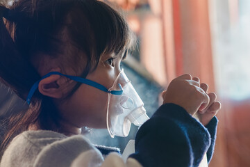 Girl using Oxygen breathing machine at home smile and surprice. Breathing device for asthma and...
