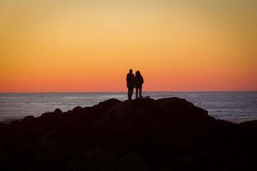 Pareja disfrutando del atardecer en la playa 