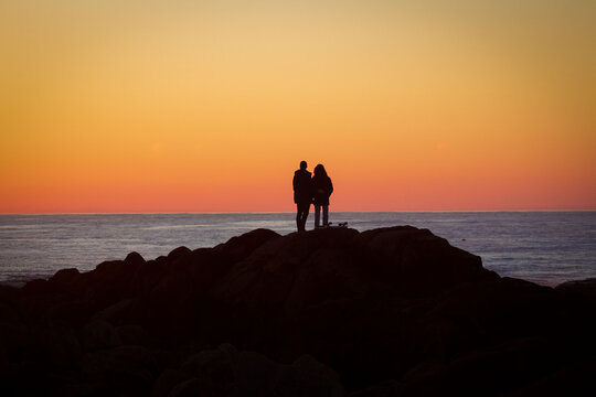 Pareja disfrutando del atardecer en la playa 