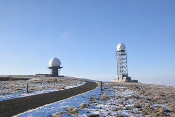 a view of the radar station at Titterstone Clee summit with the ground covered in snow and the sky clear blue