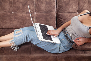 Woman using white laptop computer at home.