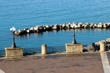 Overview of the Taranto seafront. Mar Grande with lampposts and rocks. Puglia, Italy