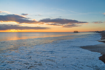 Fototapeta na wymiar The sunsetting over the English Channel viewed from Brighton Beach, UK