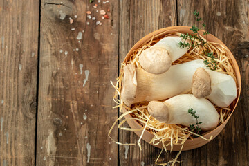 Fresh raw mushrooms, king oyster or eringi on a wooden background, banner, menu, recipe place for text, top view