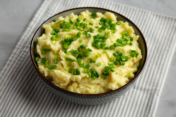 Homemade Mashed Potatoes with Chives in a Bowl, side view.