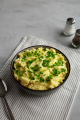 Homemade Mashed Potatoes with Chives in a Bowl, side view.