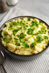 Homemade Mashed Potatoes with Chives in a Bowl, side view.