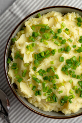 Homemade Mashed Potatoes with Chives in a Bowl, top view. Flat lay, overhead, from above.