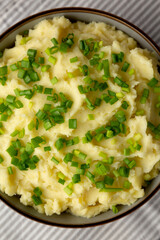 Homemade Mashed Potatoes with Chives in a Bowl, top view. Flat lay, overhead, from above.