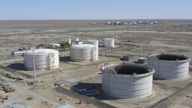 Huge round tanks for oil stand in the middle of a desert area.