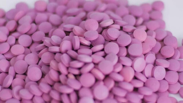production of tablets conveyor. Pills Purple color close-up Macro