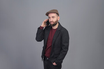 Young man talking on the phone in a studio shot - 565303100
