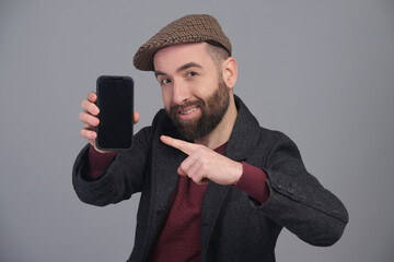 Young man pointing the phone at the camera in a studio shot - 565303116