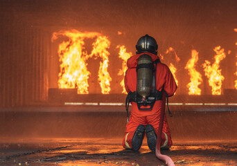 Firemen use extinguisher water fight fire burn during firefight training. Firefighter wearing fire...