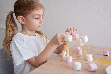 Kid having fun with a chemistry molecular atom model tool learning biology and chemistry class...
