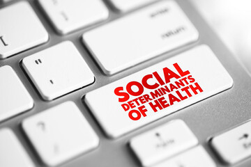 Social determinants of health - economic and social conditions that influence individual and group differences in health status, text concept button on keyboard - obrazy, fototapety, plakaty