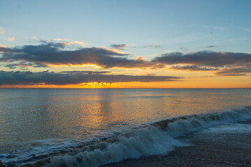 Fototapeta na wymiar The sunsetting over the English Channel viewed from Brighton Beach, UK