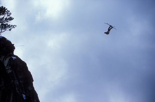 Ski-BASE jumper doing a front flip off a cliff near Lake Tahoe.
