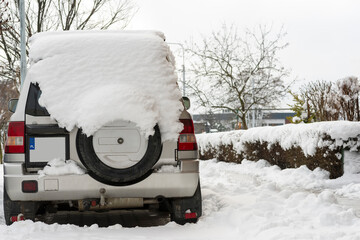 Fototapeta Mały , terenowy samochód produkcji japońskiej , pokryty sporą ilością śniegu , zaparkowany na zaśnieżonym parkingu osiedlowym . obraz